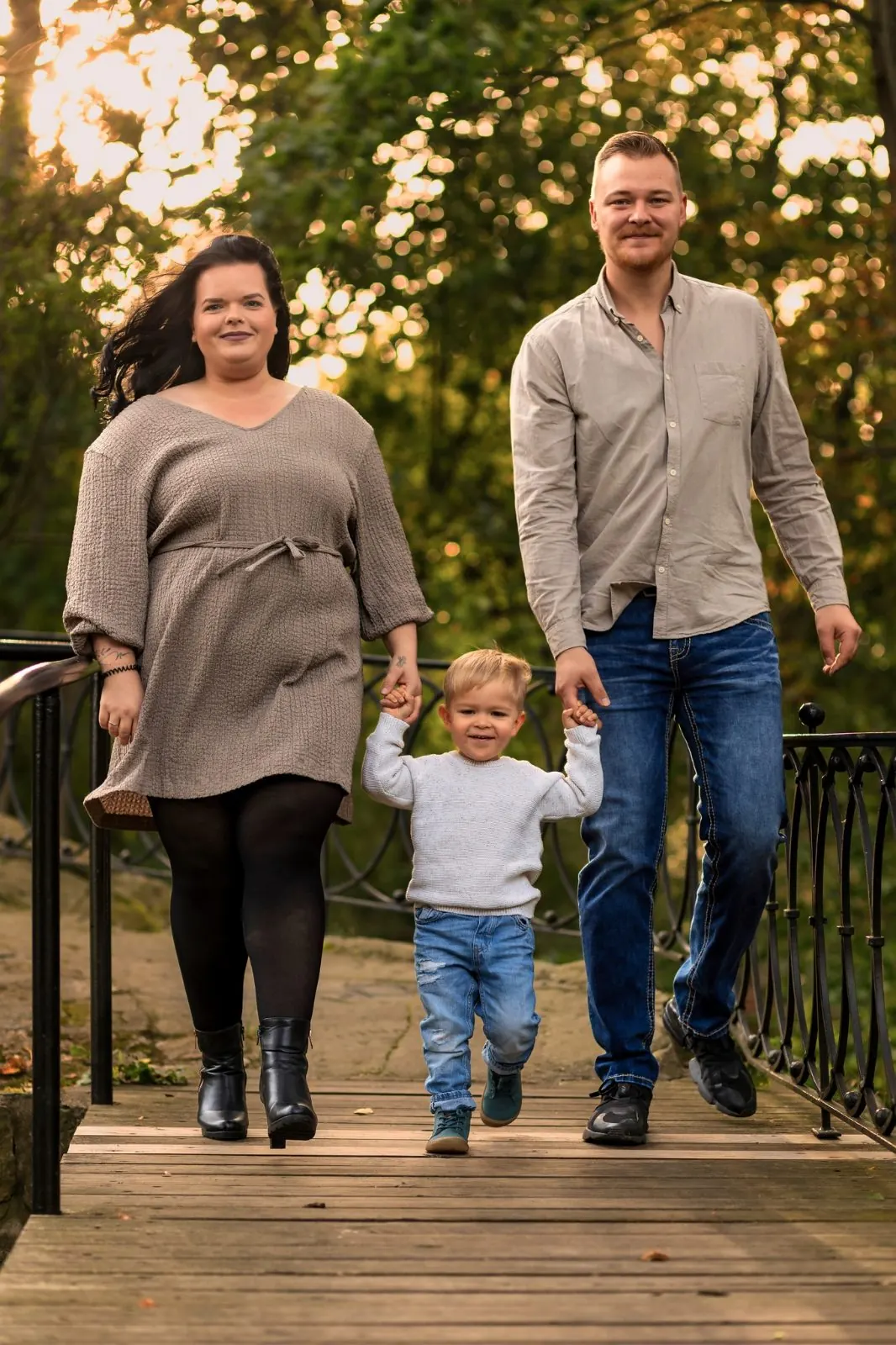 Familie auf einer Holzbrücke im Herbst