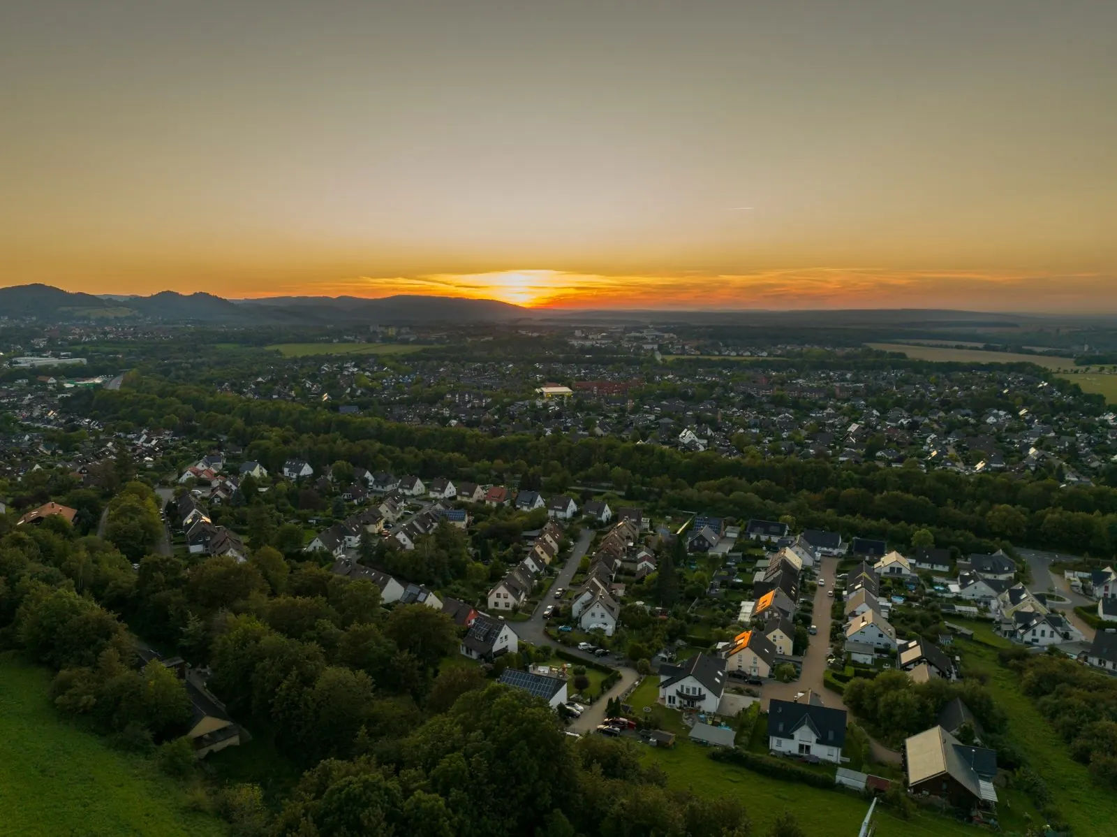 Drohnenaufnahme einer Stadt bei Sonnenuntergang
