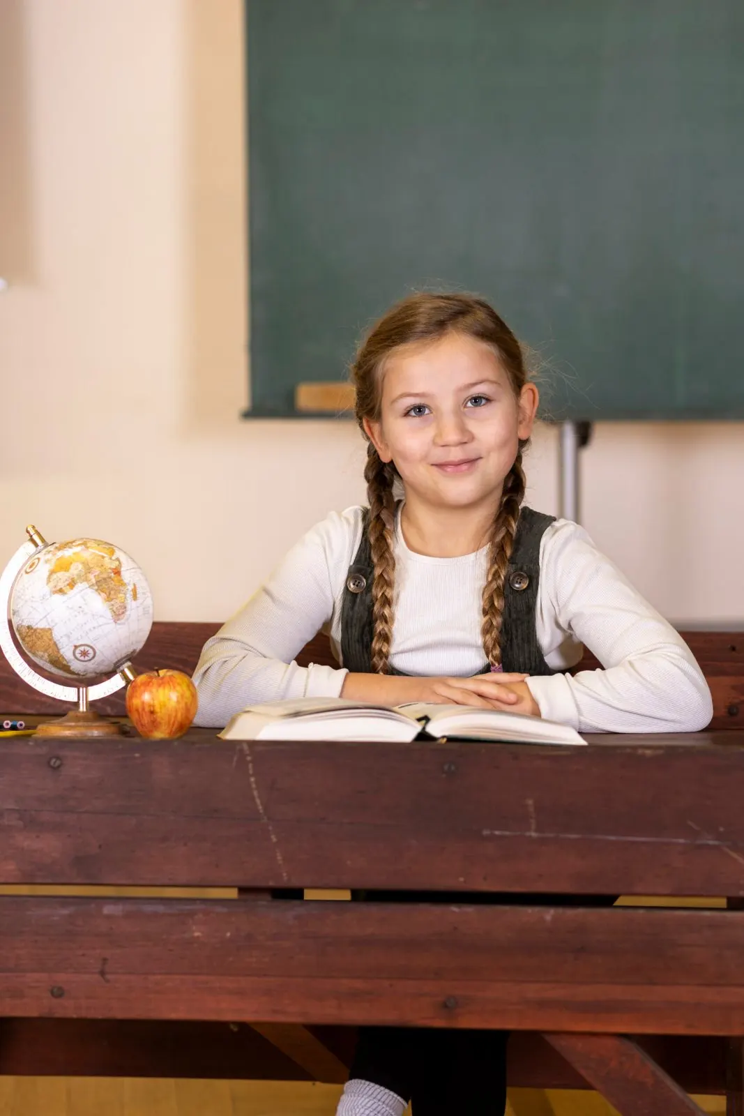 Schulkind am Pult vor einer Tafel